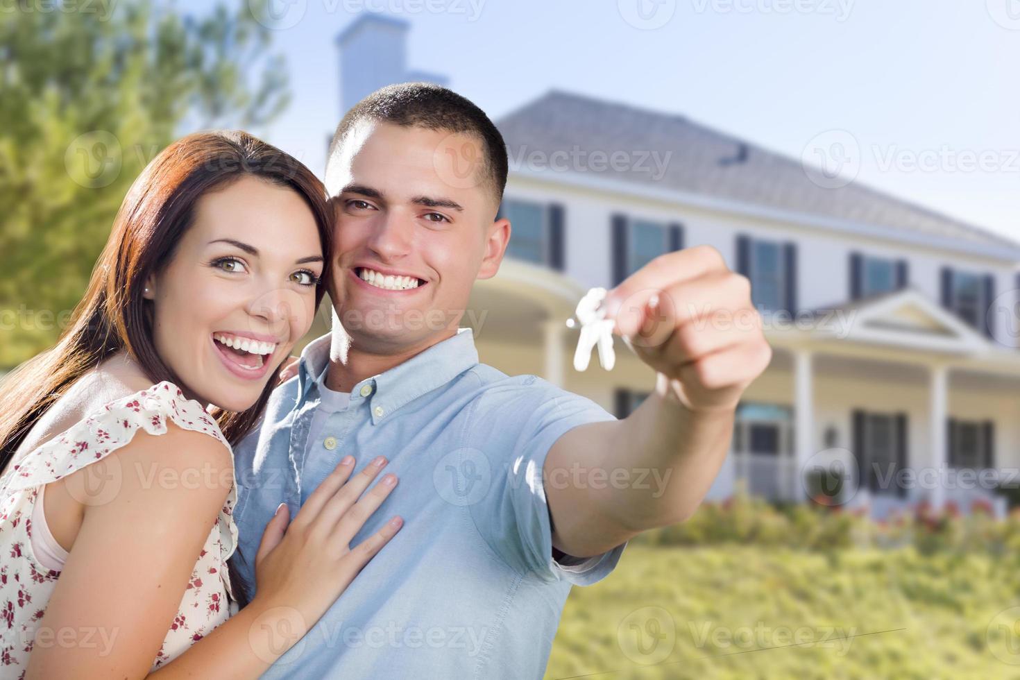 Military Couple with House Keys In Front of New Home photo