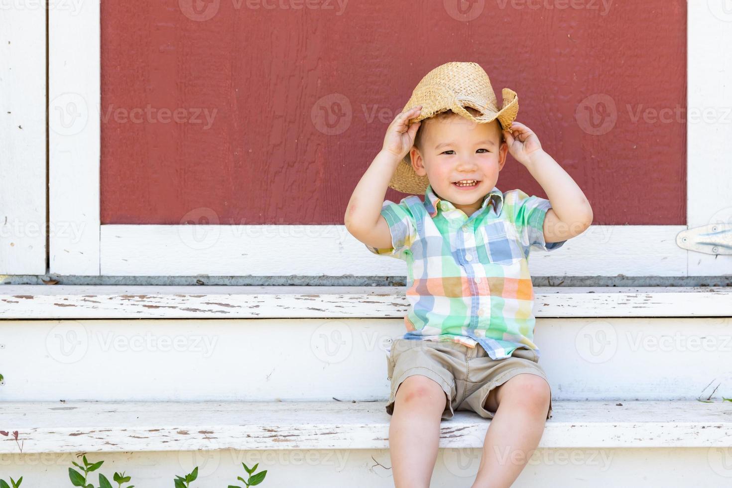 Young Mixed Race Chinese and Caucasian Boy Wearing Cowboy Hat Relaxing On The Steps photo