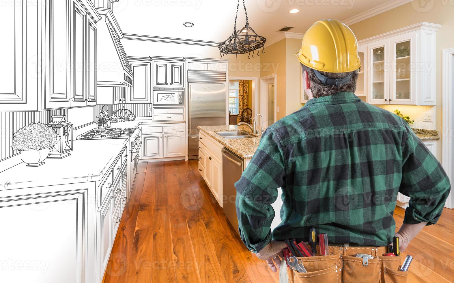 Male Contractor with Hard Hat and Tool Belt Looking At Custom Kitchen Drawing Photo Combination On White.