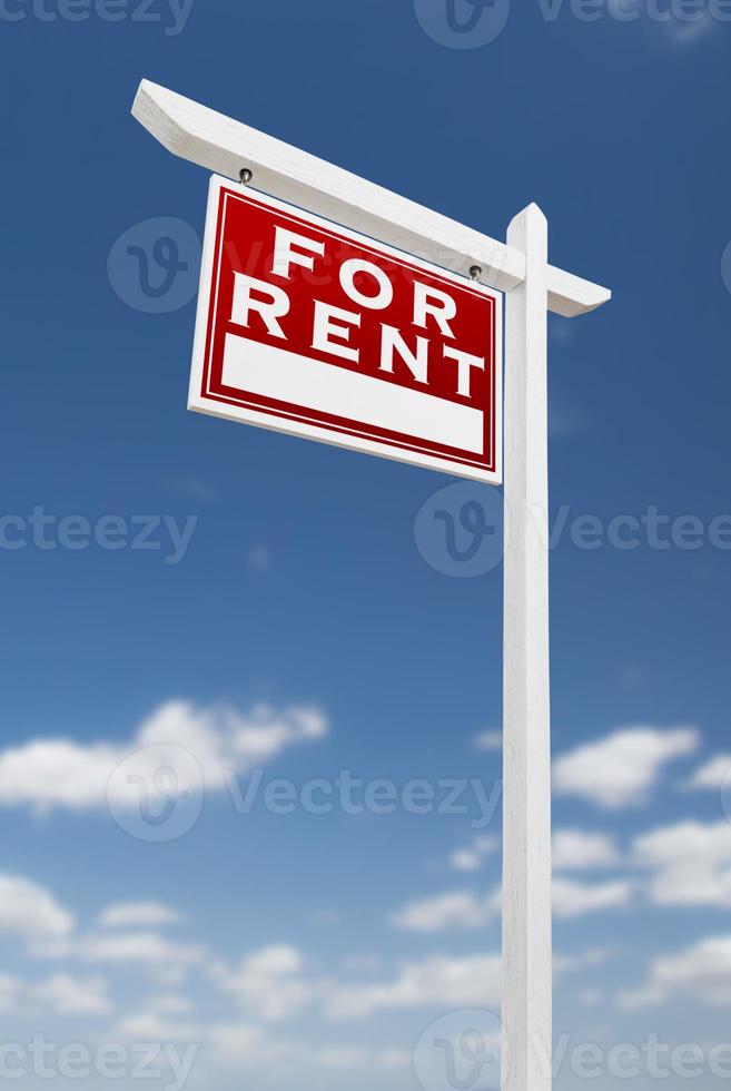 Left Facing For Rent Real Estate Sign on a Blue Sky with Clouds. photo