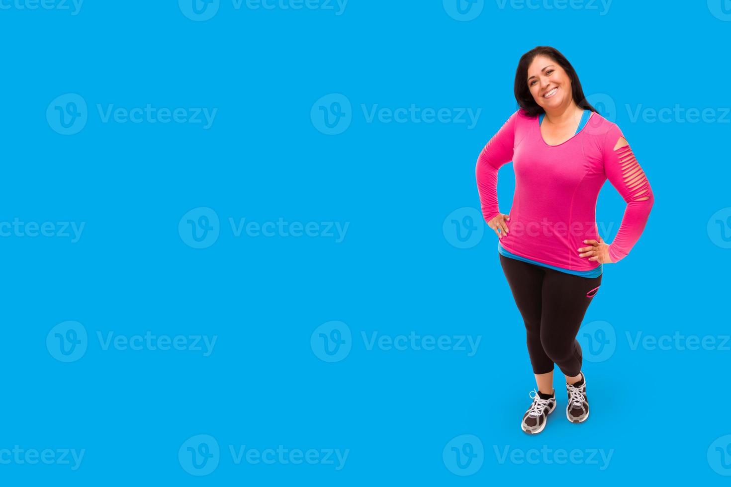 Middle Aged Hispanic Woman In Workout Clothes Against A Bright Cyan Blue Background photo