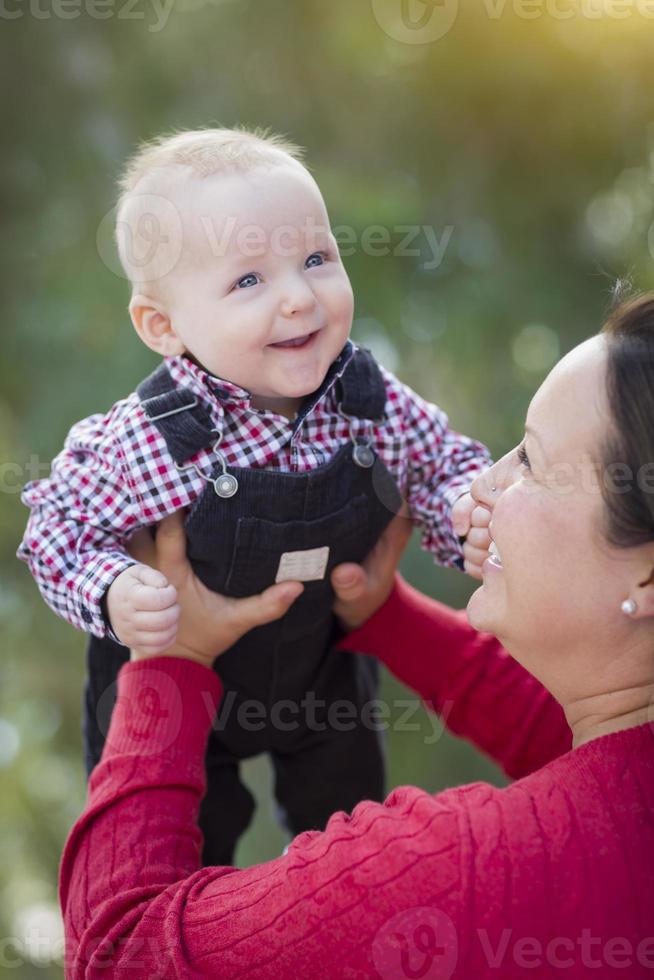 pequeño bebé divirtiéndose con mamá al aire libre foto