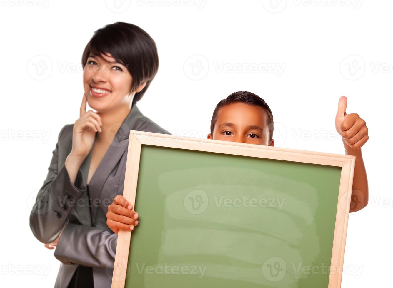 Hispanic Boy Holding Chalk Board and Female Teacher Behind photo