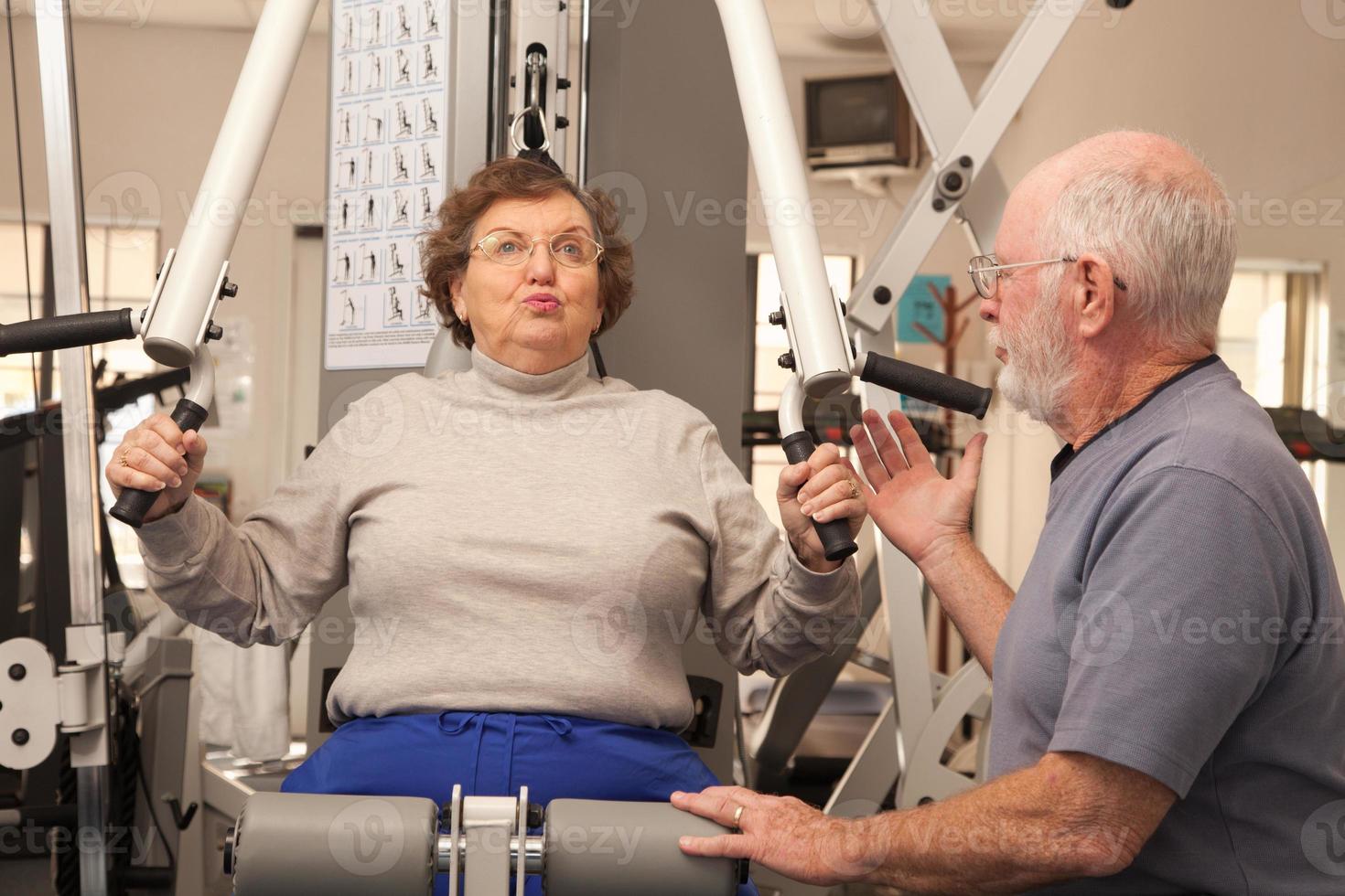 pareja de adultos mayores haciendo ejercicio juntos en el gimnasio foto