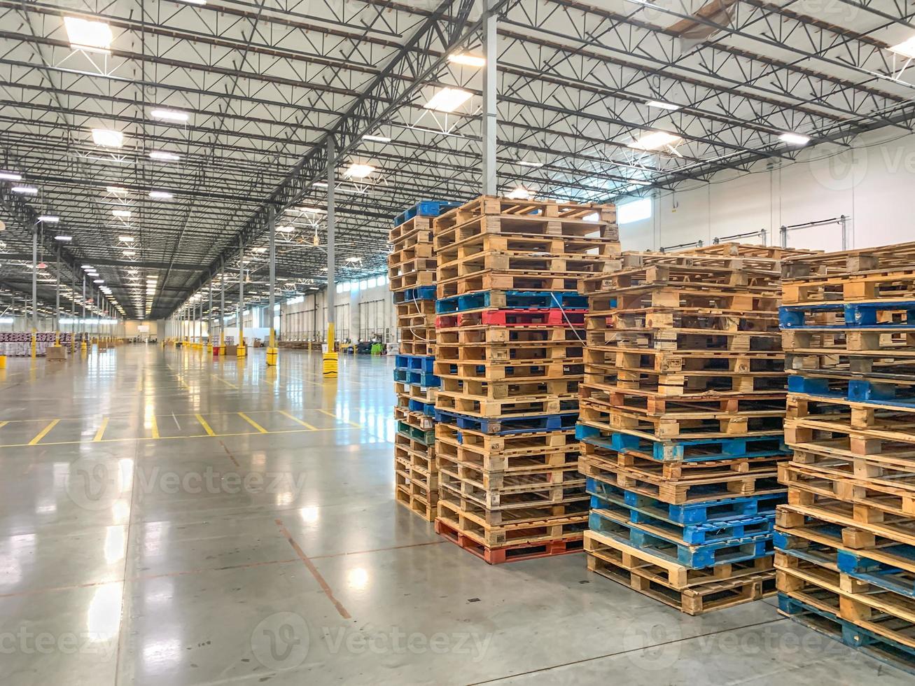 Massive Empty Industrial Warehouse Interior With Stacked Pallets photo