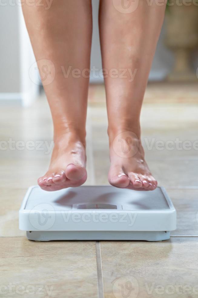 mujer flotando ligeramente por encima de la superficie de la báscula foto