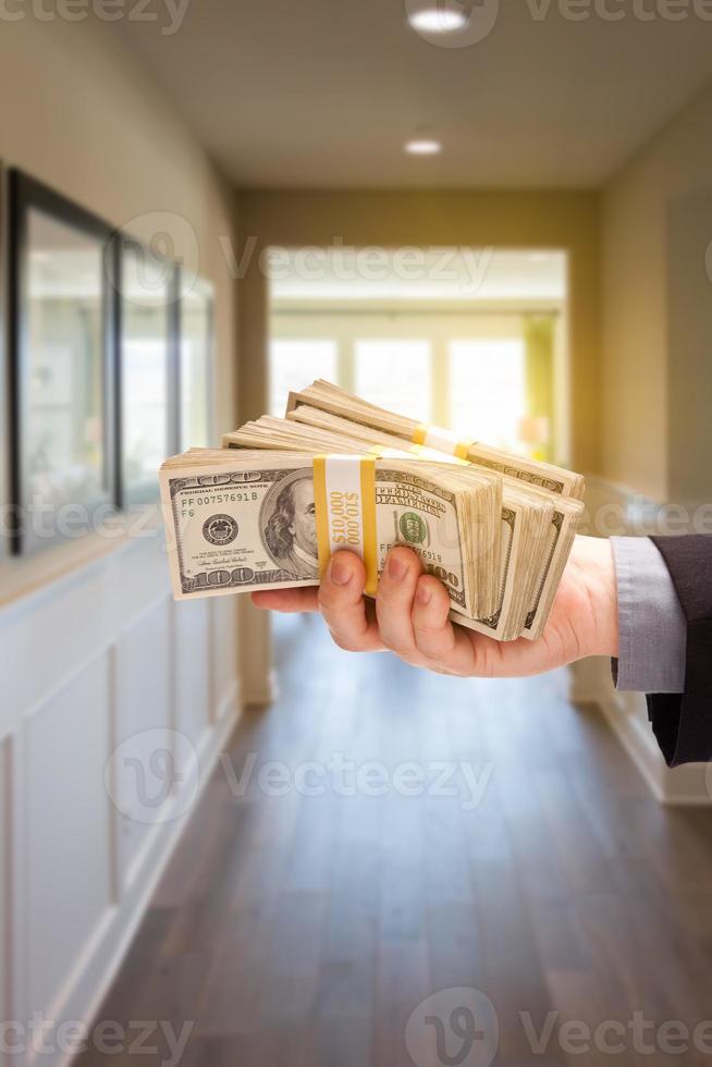 mano masculina con una pila de dinero en efectivo dentro del pasillo de la casa foto