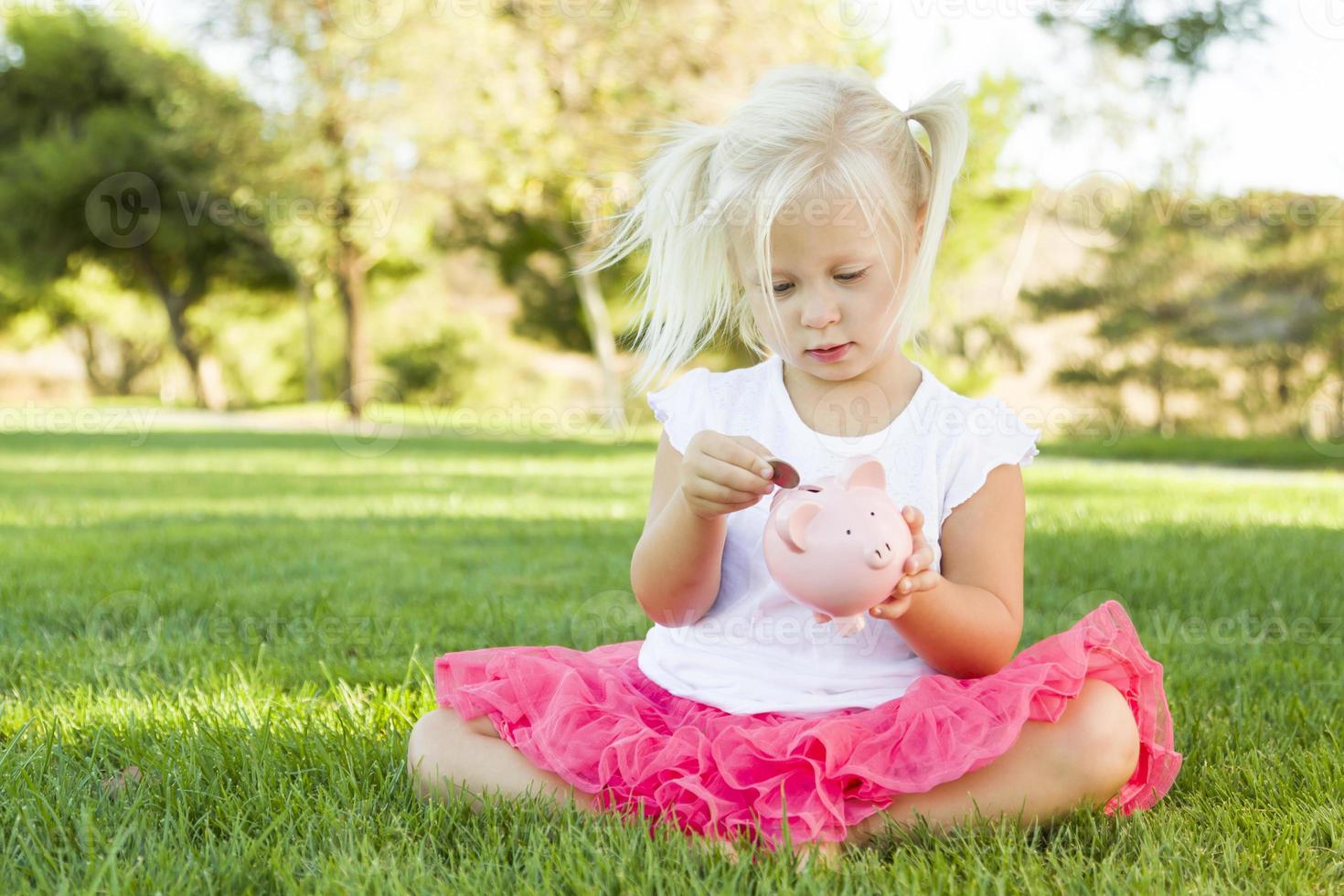 Little Girl Having Fun with Her Piggy Bank Outside photo