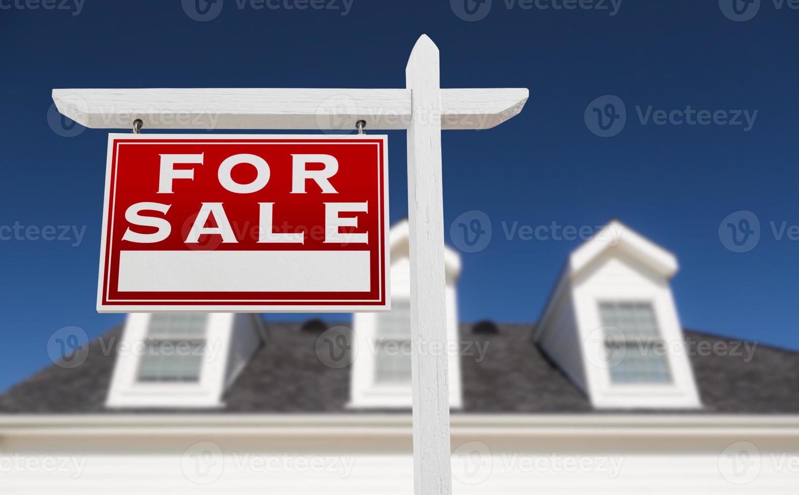 Left Facing For Sale Real Estate Sign In Front of House and Deep Blue Sky. photo