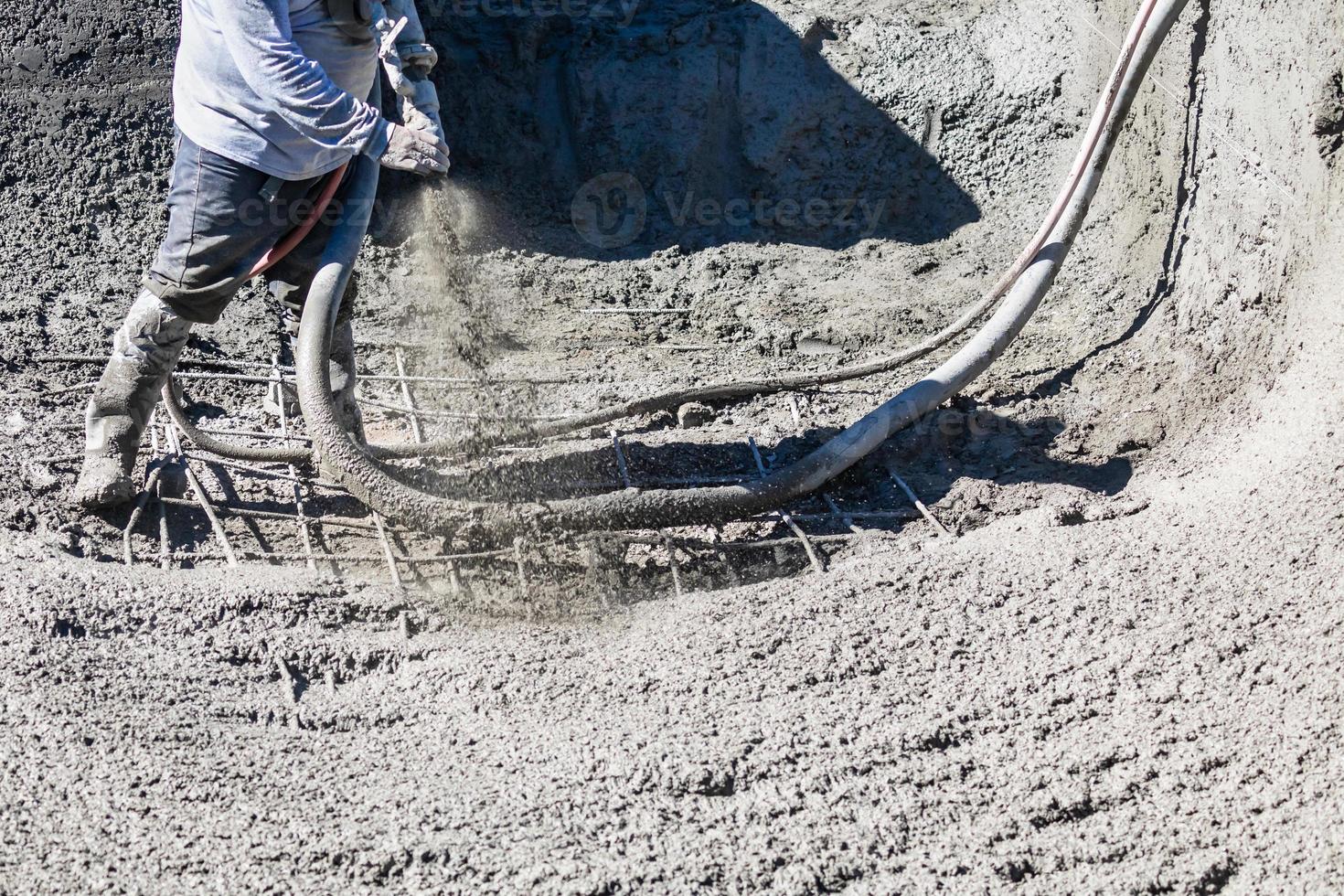 Pool Construction Worker Shooting Concrete, Shotcrete or Gunite Through Hose photo