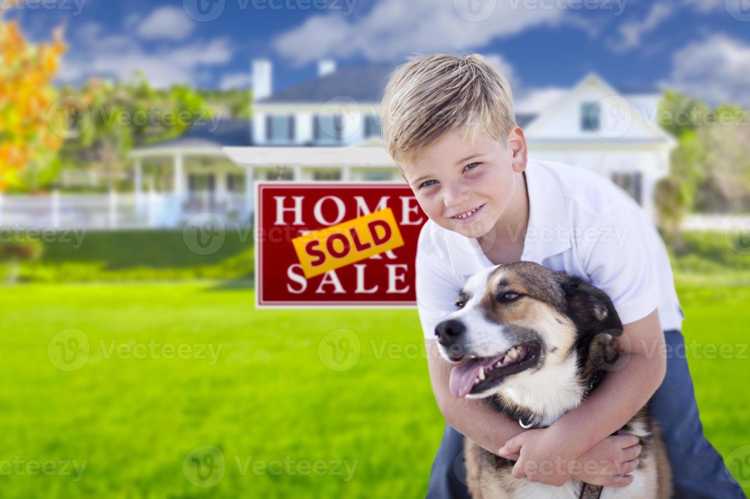 niño y su perro frente al letrero vendido, casa foto