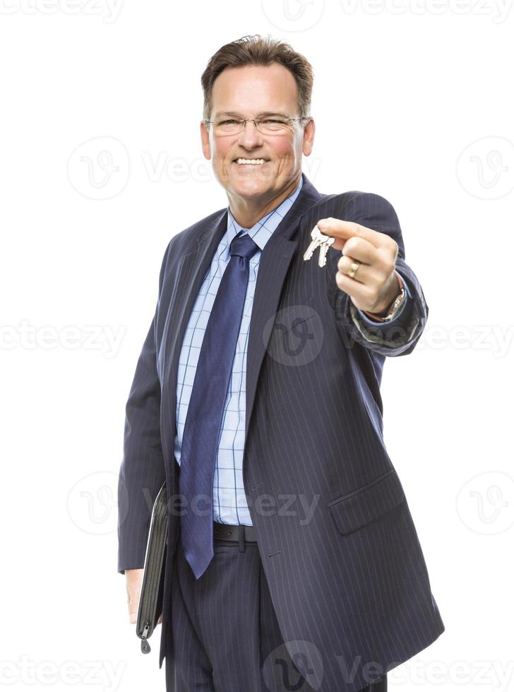 Handsome Real Estate Agent Holding Out Keys to New Home photo
