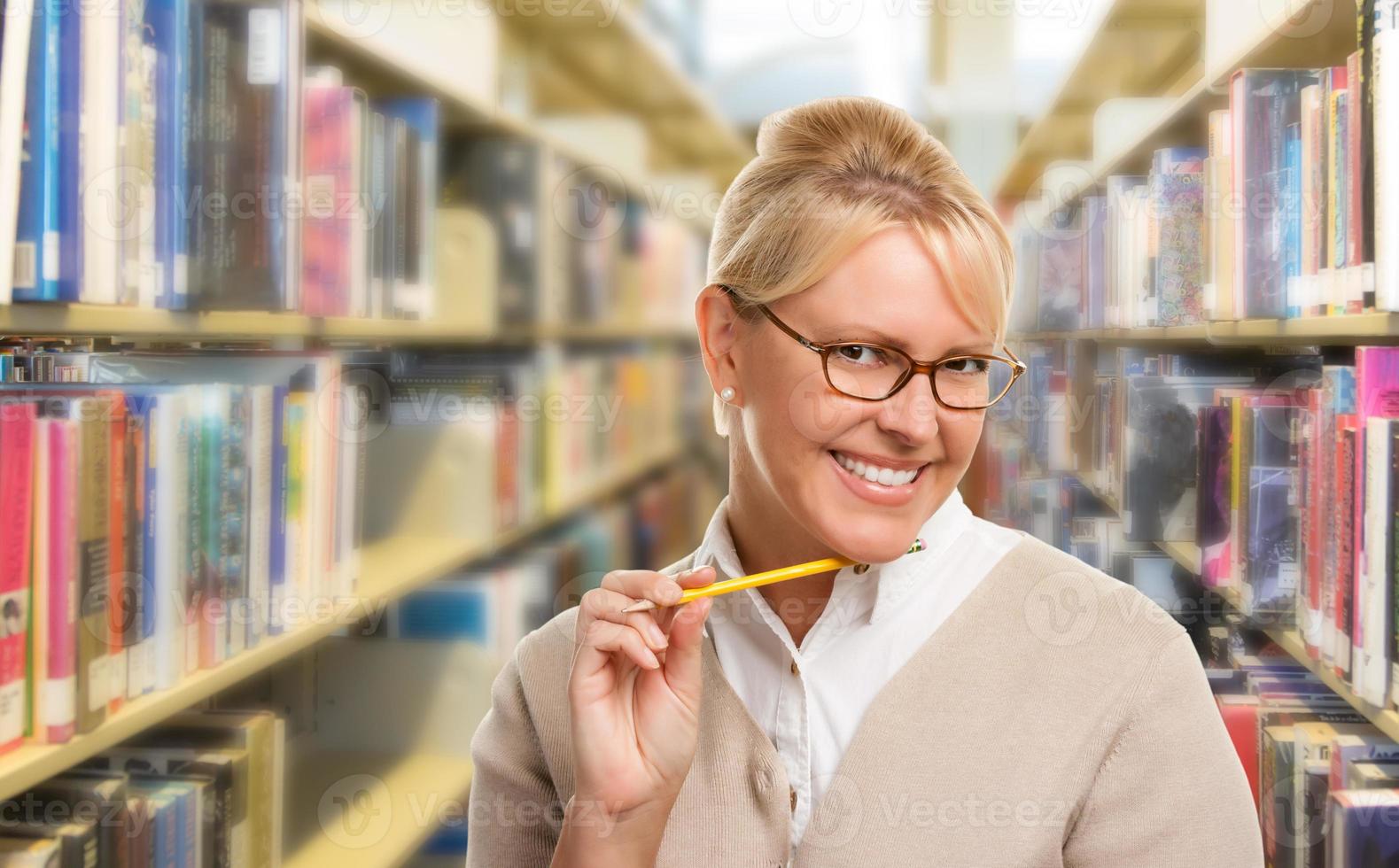 hermoso estudiante expresivo o profesor con lápiz en la biblioteca. foto