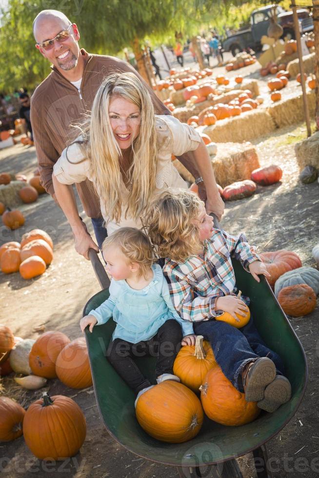 familia joven disfruta de un día en el huerto de calabazas foto