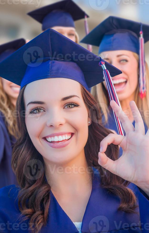 Happy Graduating Group of Girls In Cap and Gown Celebrating on Campus. photo