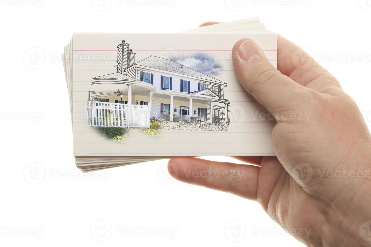 mano masculina sosteniendo una pila de tarjetas flash con dibujo de casa foto