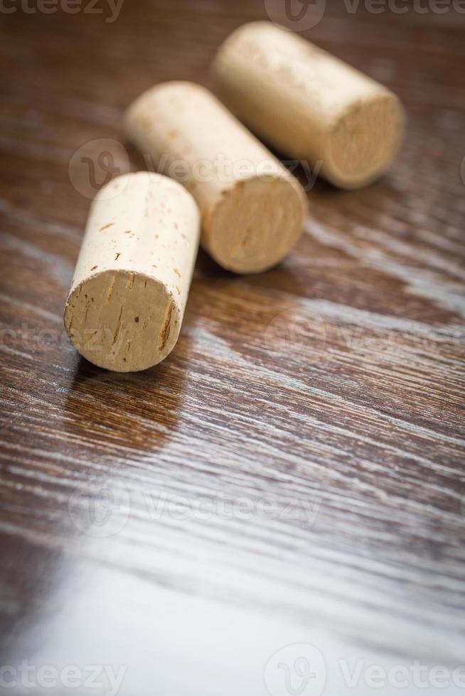 Blank Wine Corks Resting on Reflective wood Surface. photo
