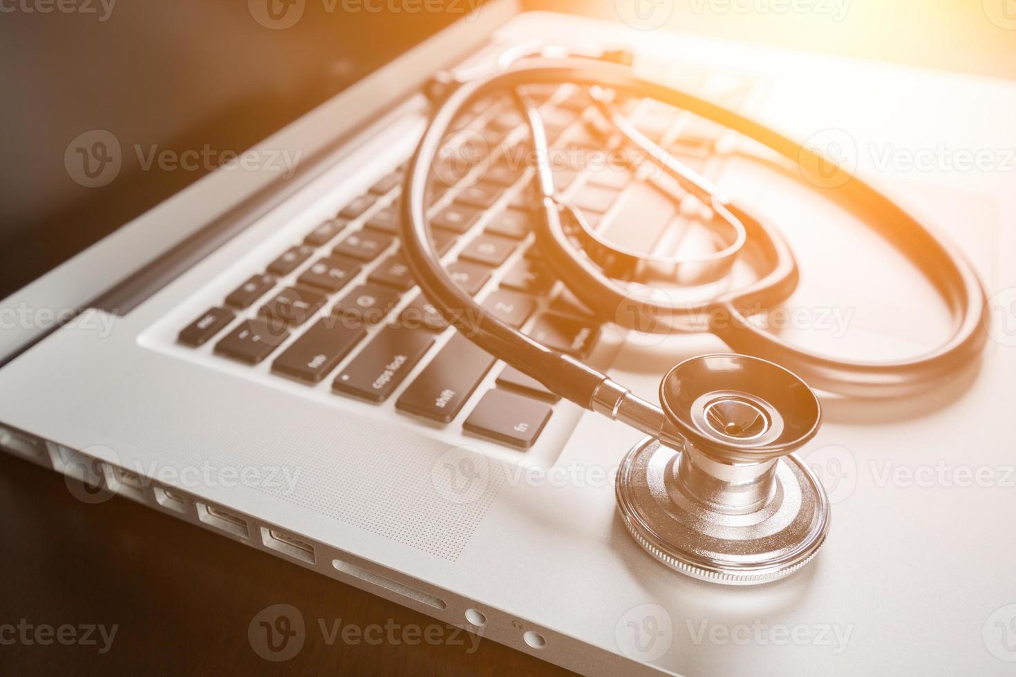 Medical Stethoscope Resting on Laptop Computer Keyboard. photo