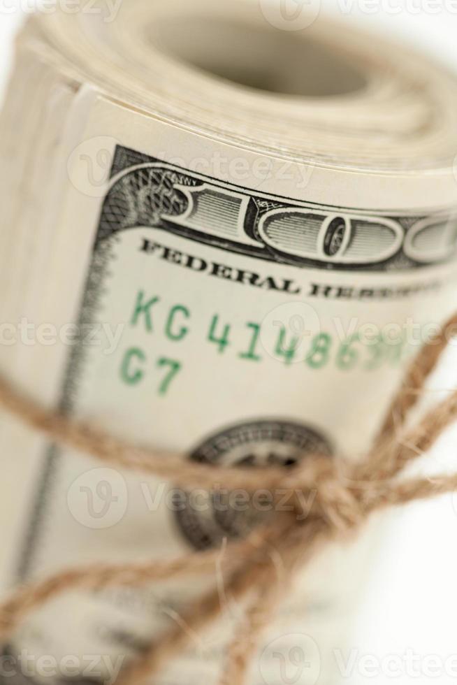 Roll of One Hundred Dollar Bills Tied in Burlap String on White photo