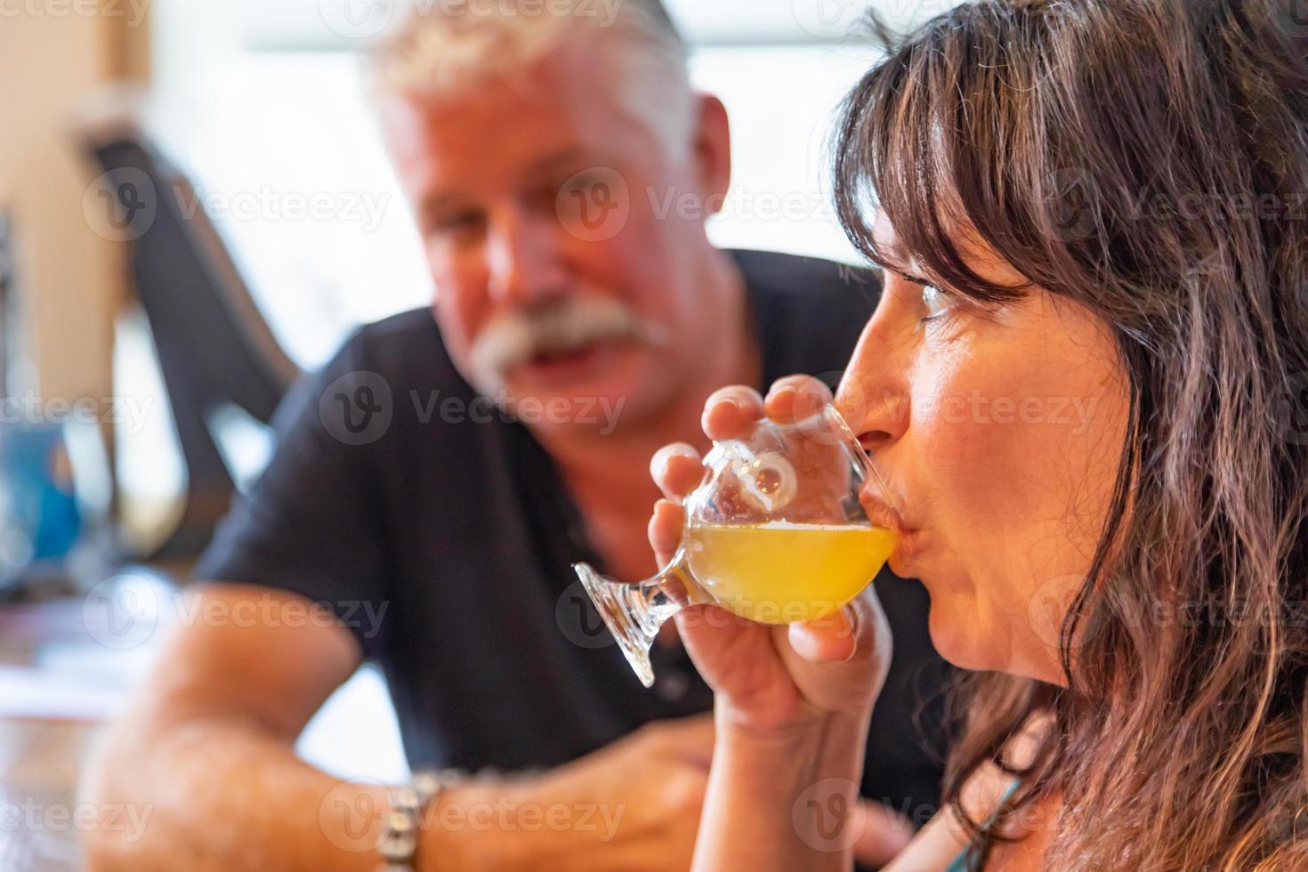 pareja disfrutando de vasos de cerveza artesanal en el bar foto