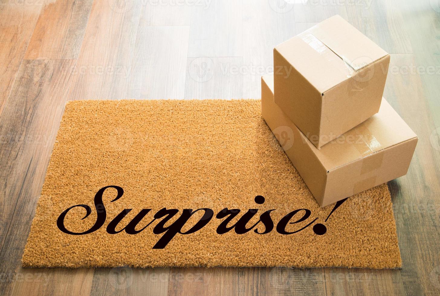 Surprise Welcome Mat On Wood Floor With Shipment of Boxes photo