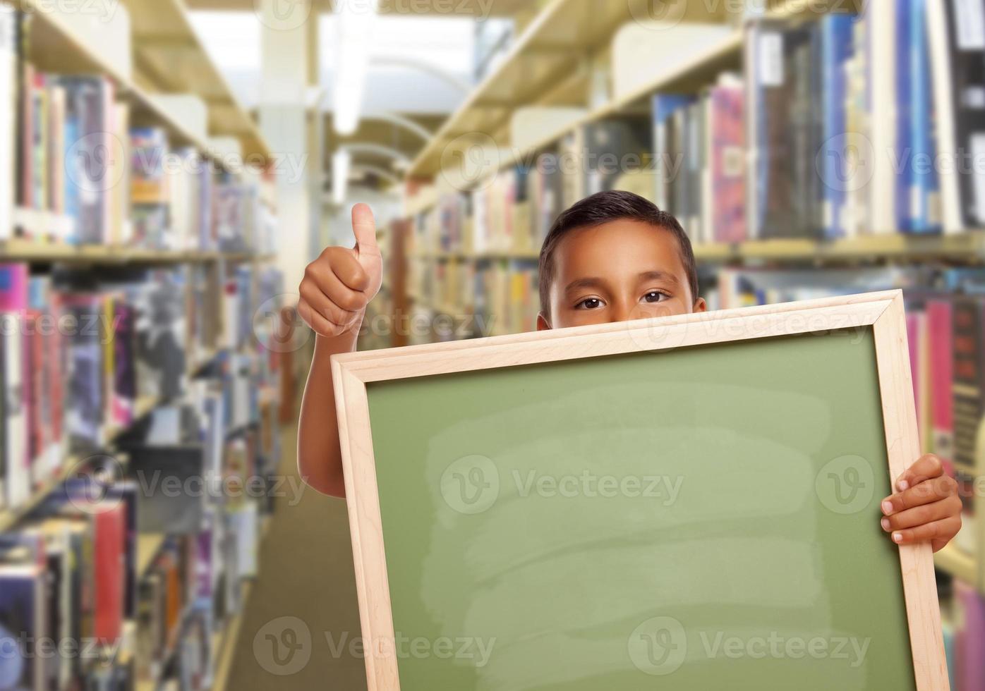 Hispanic Boy with Empty Chalk Board in Library photo