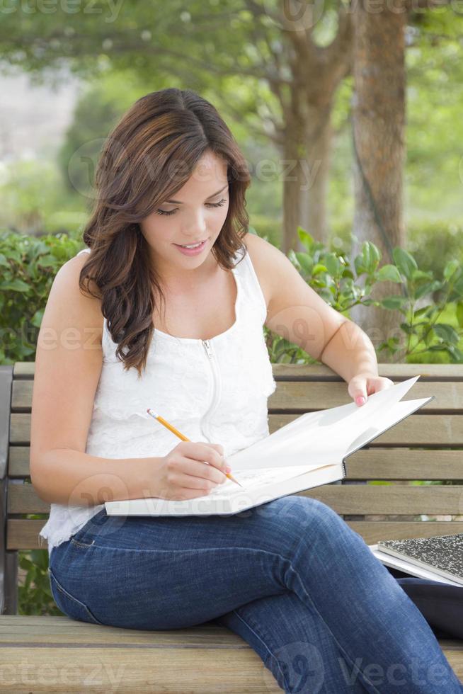 Young Adult Female Student on Bench Outdoors photo