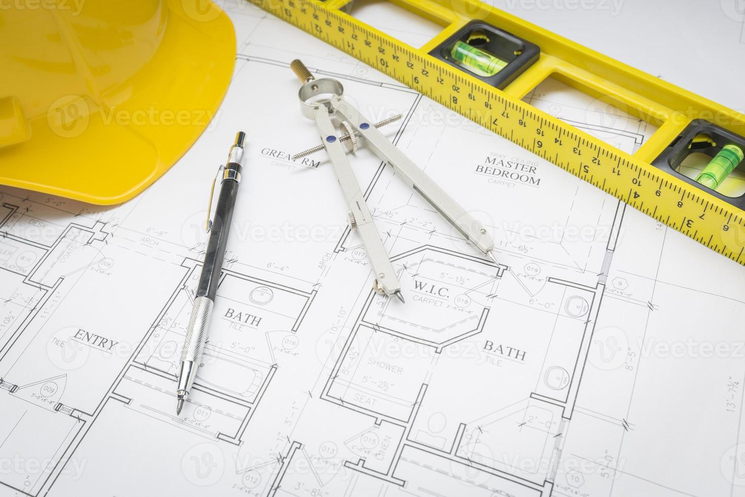 Hard Hat, Pencil, Level and Compass Resting on House Plans photo