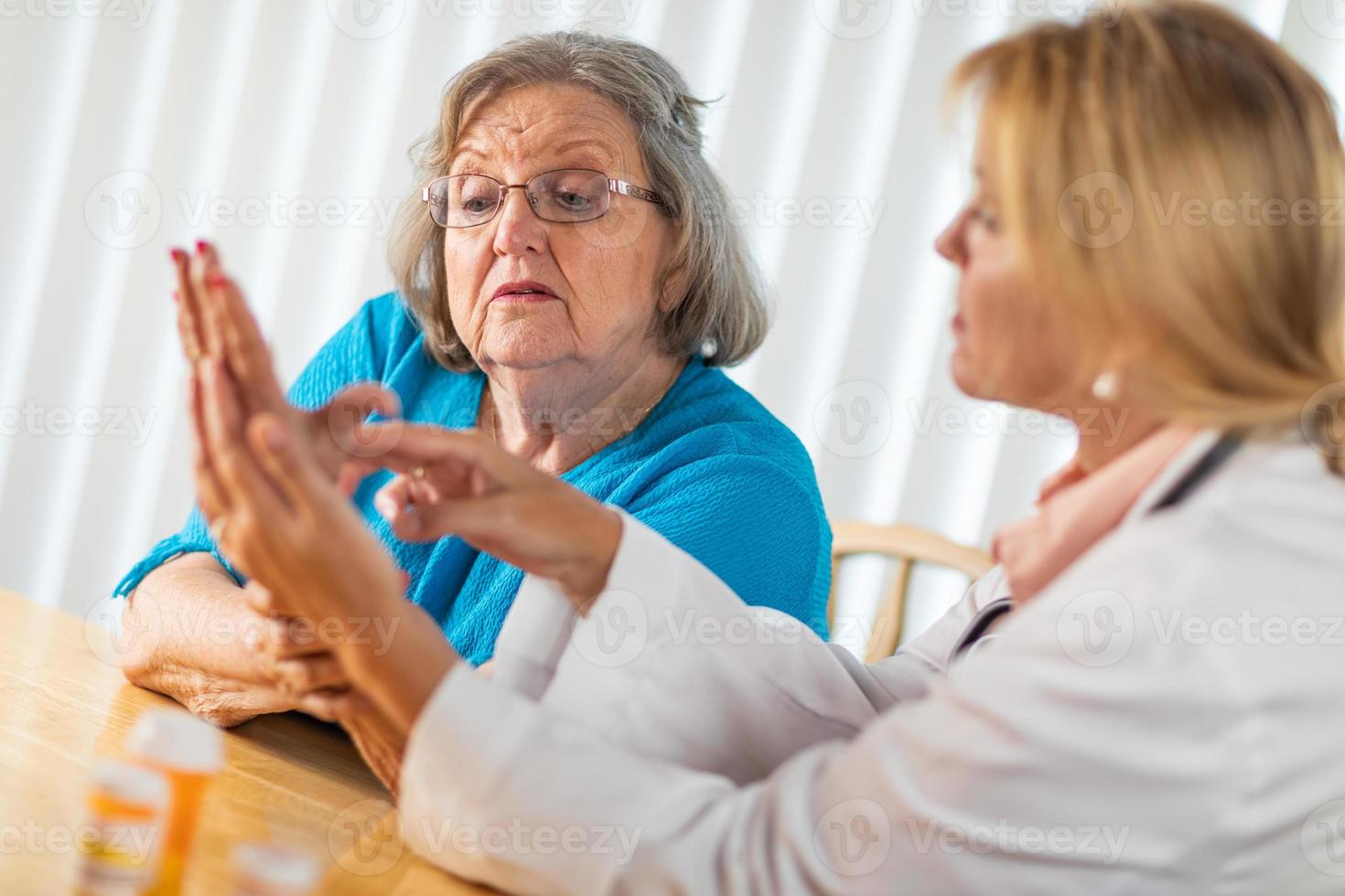 Female Doctor Talking with Senior Adult Woman About Hand Therapy photo