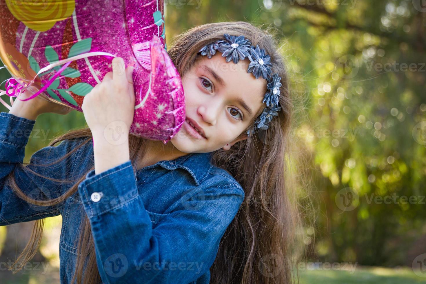 lindo, joven, carrera mezclada, niña, tenencia, mylar, globo, aire libre foto