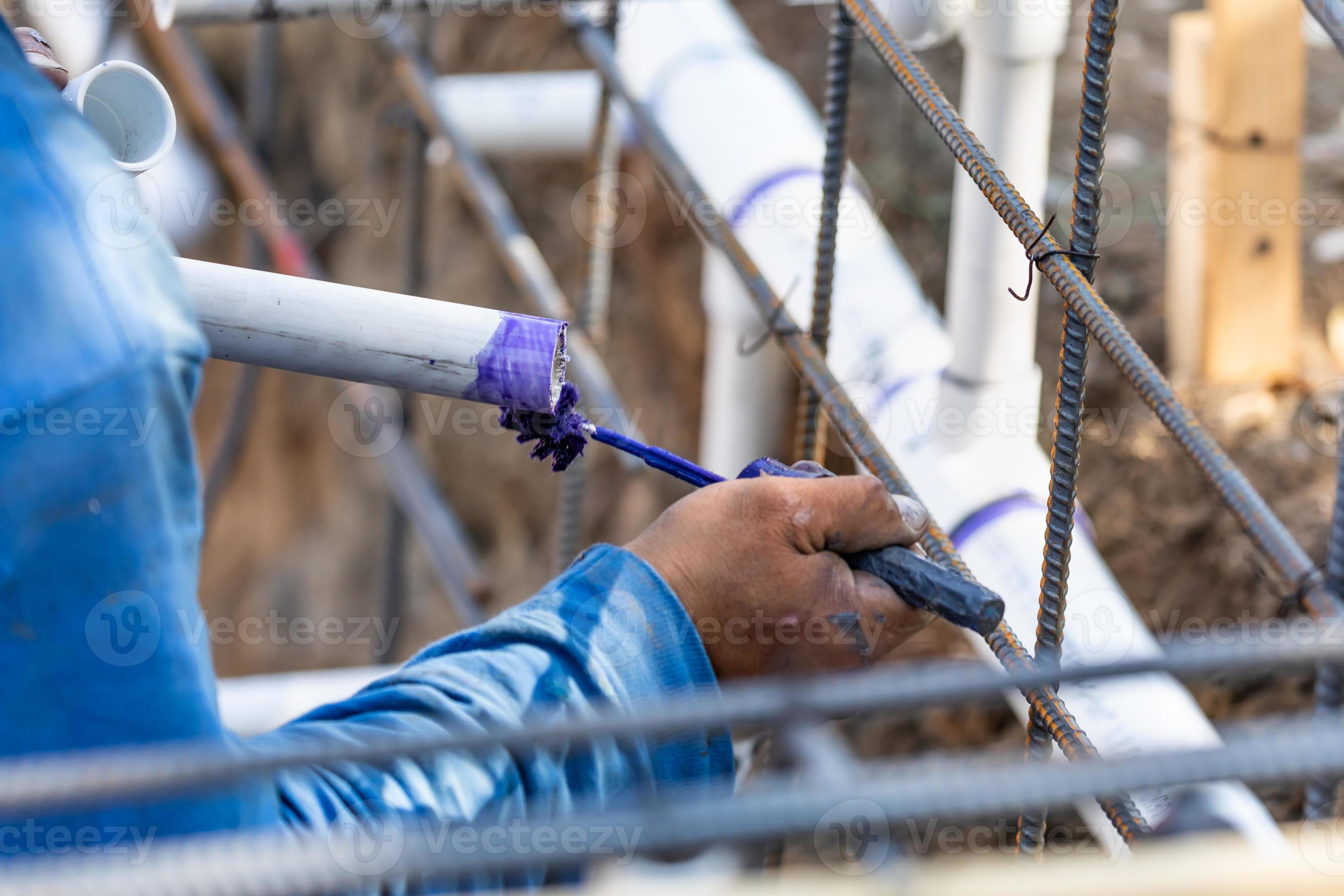 Plumber Applying Pipe Cleaner, Primer and Glue to PVC Pipe At Construction Site 16368361 Stock