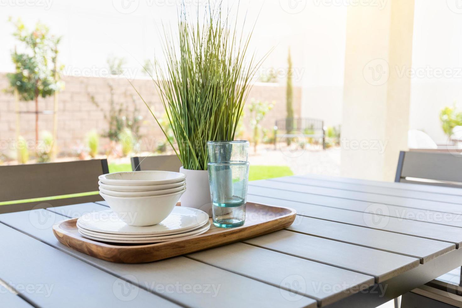 Outdoor Patio Setting with Dishes and Glasses on Tray photo