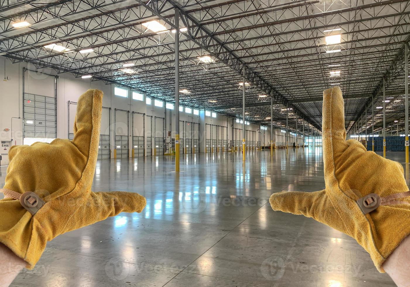 Framing Hands Wearing Leather Construction Gloves in Empty Industrial Warehouse. photo