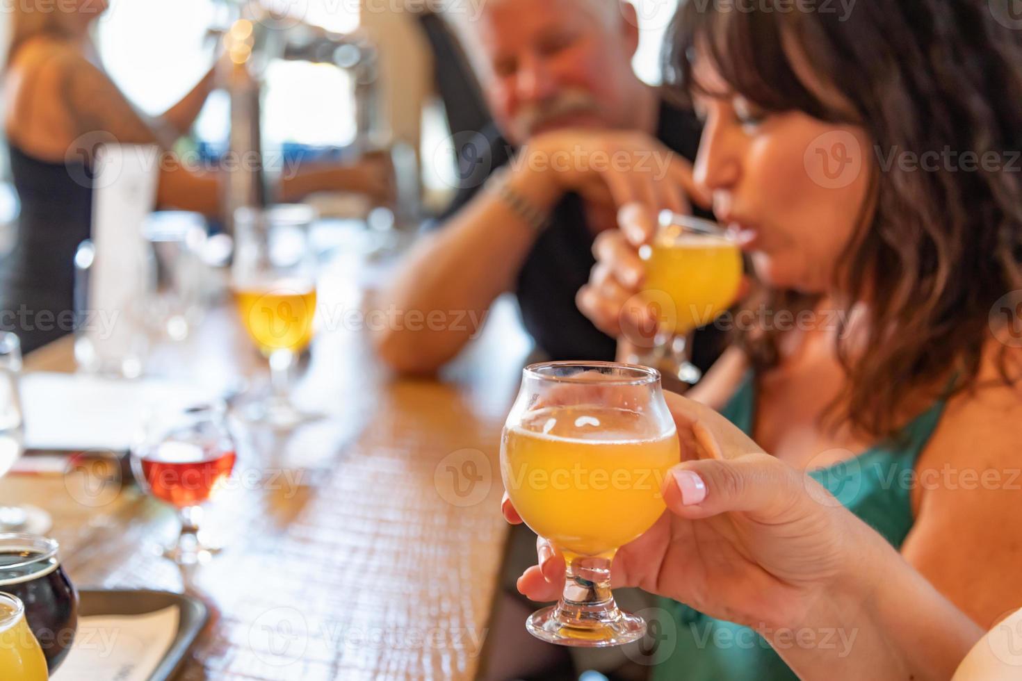 Group of Friends Enjoying Glasses of Micro Brew Beer At Bar photo