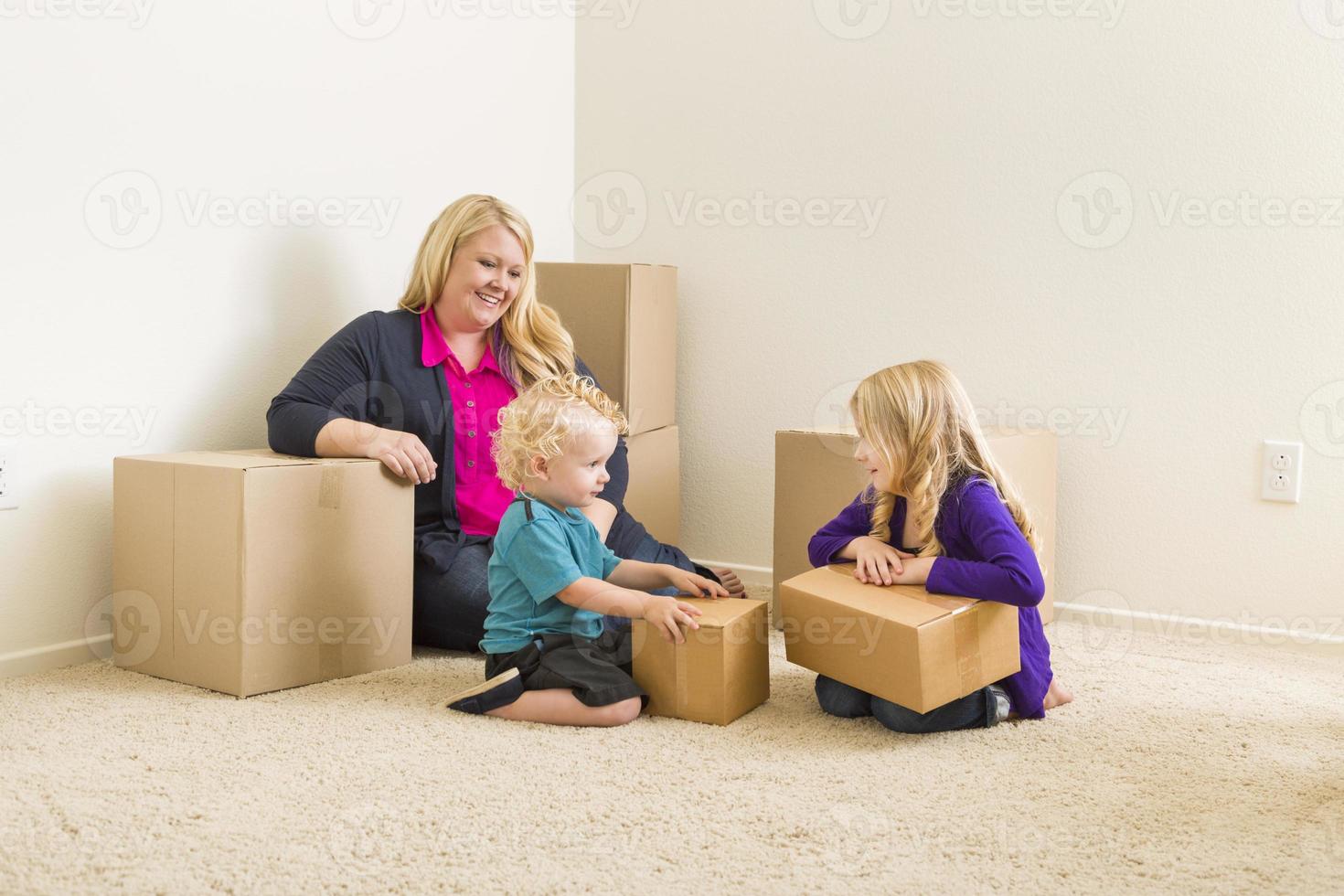 familia joven en una habitación vacía con cajas móviles foto