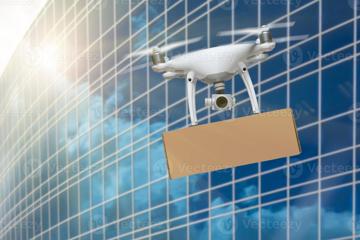 sistema de aeronaves no tripuladas uas quadcopter drone que lleva un paquete en blanco cerca del edificio corporativo foto