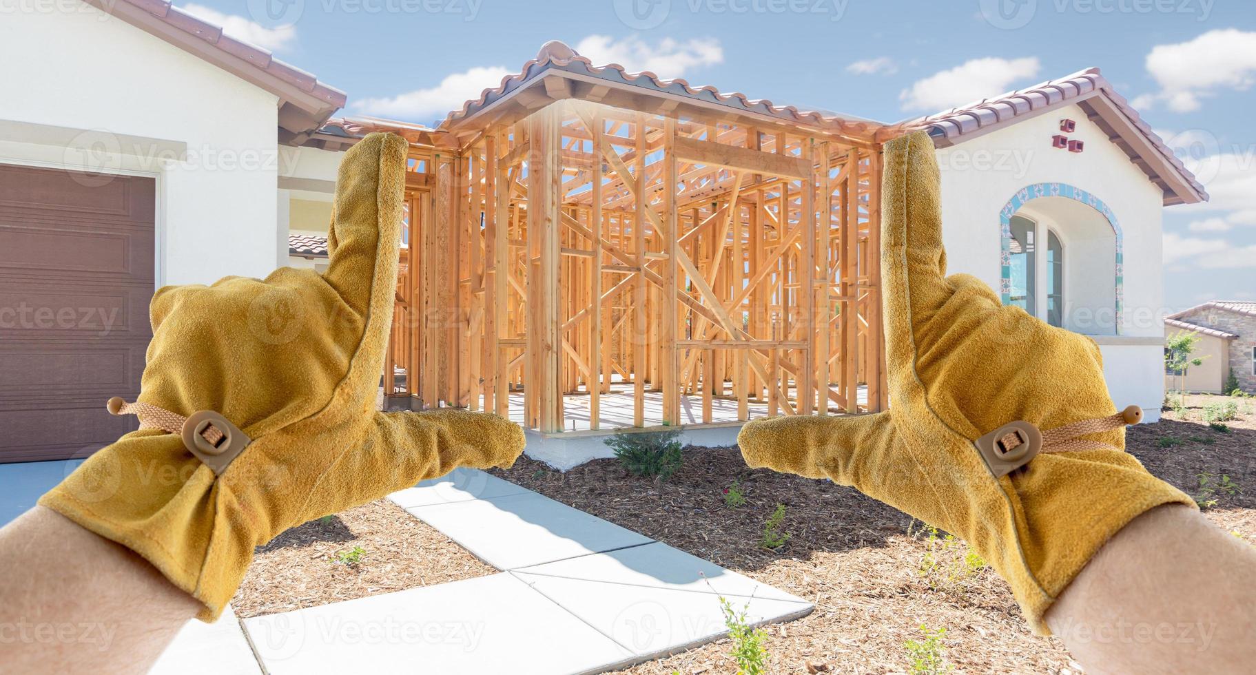 Male Contractor Hands Framing Unfinished Section of House photo