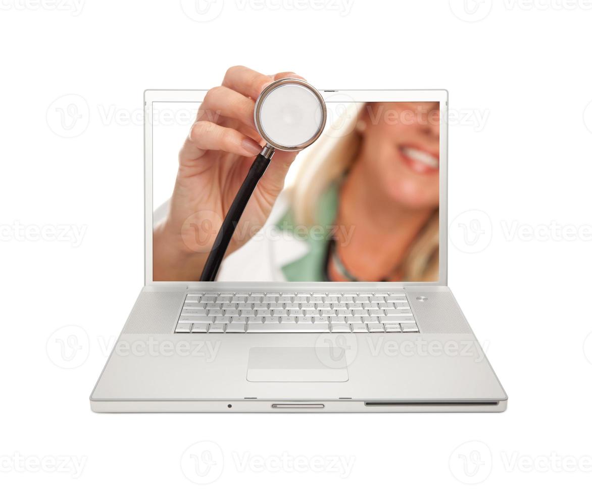 doctora sosteniendo estetoscopio a través de la pantalla del portátil foto
