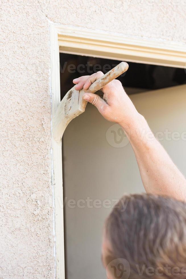 Professional Painter Cutting In With Brush to Paint House Door Frame. photo