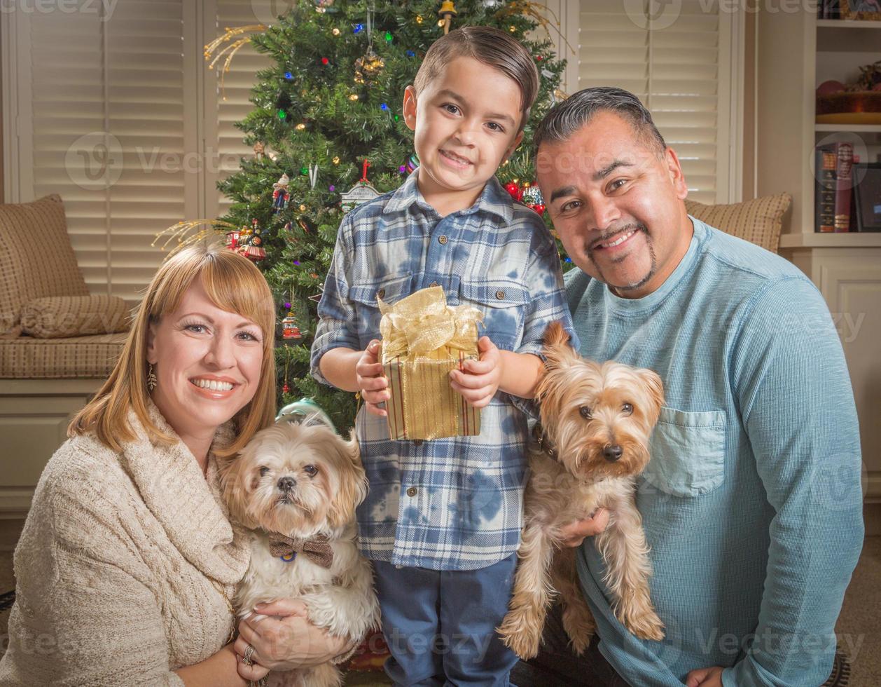 familia joven de raza mixta frente al árbol de navidad foto