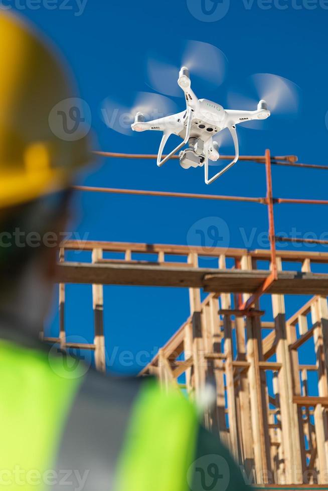 mujer piloto vuela drone quadcopter inspeccionando el sitio de construcción foto