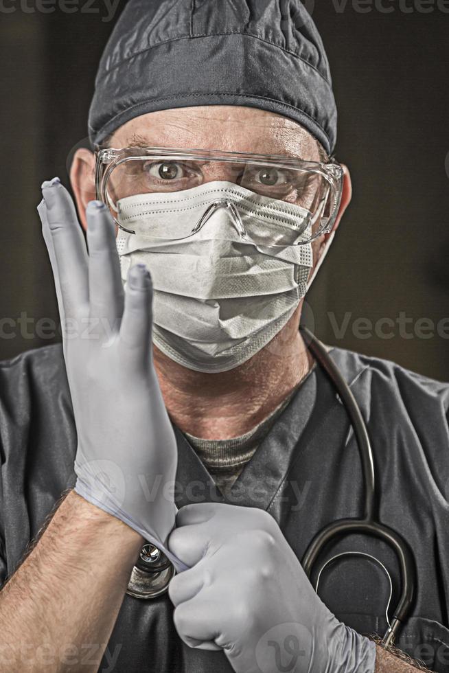 Male Doctor or Nurse Wearing Scrubs, Protective Face Mask and Goggles photo