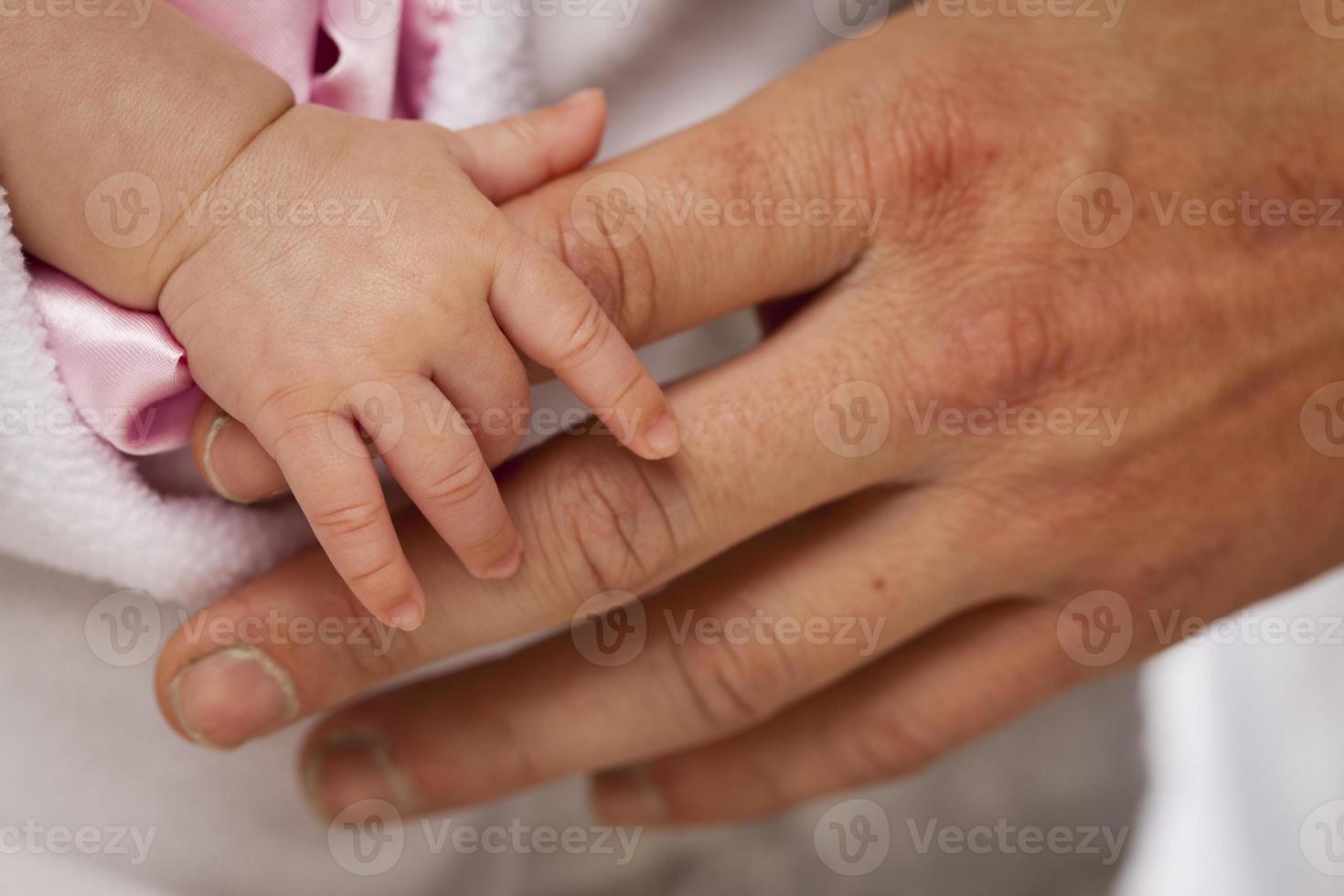Baby Girl Hand Holding Rough Finger of Dad photo