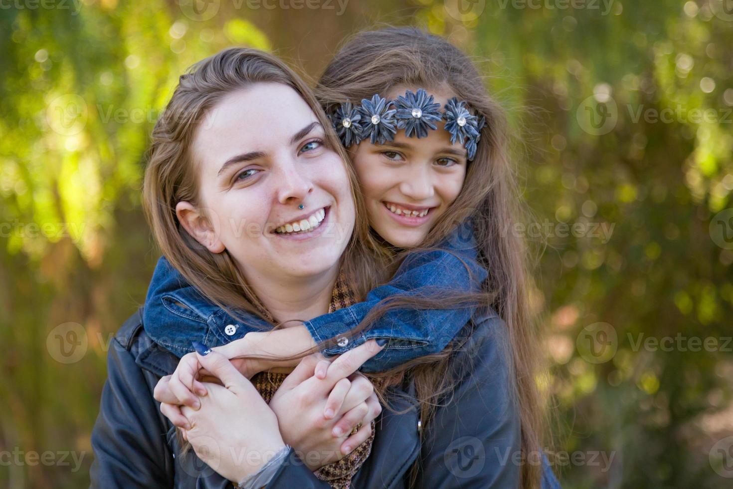 Madre caucásica cariñosa y retrato de hija de raza mixta al aire libre foto