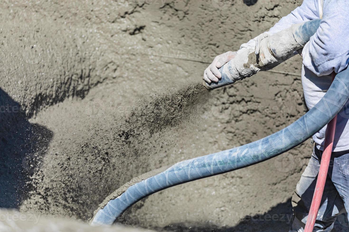 Pool Construction Worker Shooting Concrete, Shotcrete or Gunite Through Hose photo