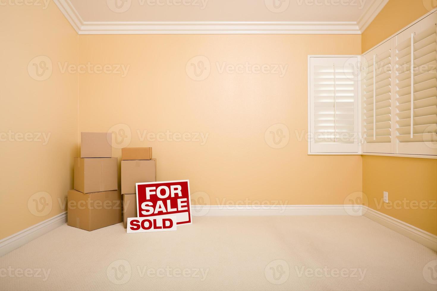 Boxes, Sale and Sold Real Estate Signs in Empty Room photo