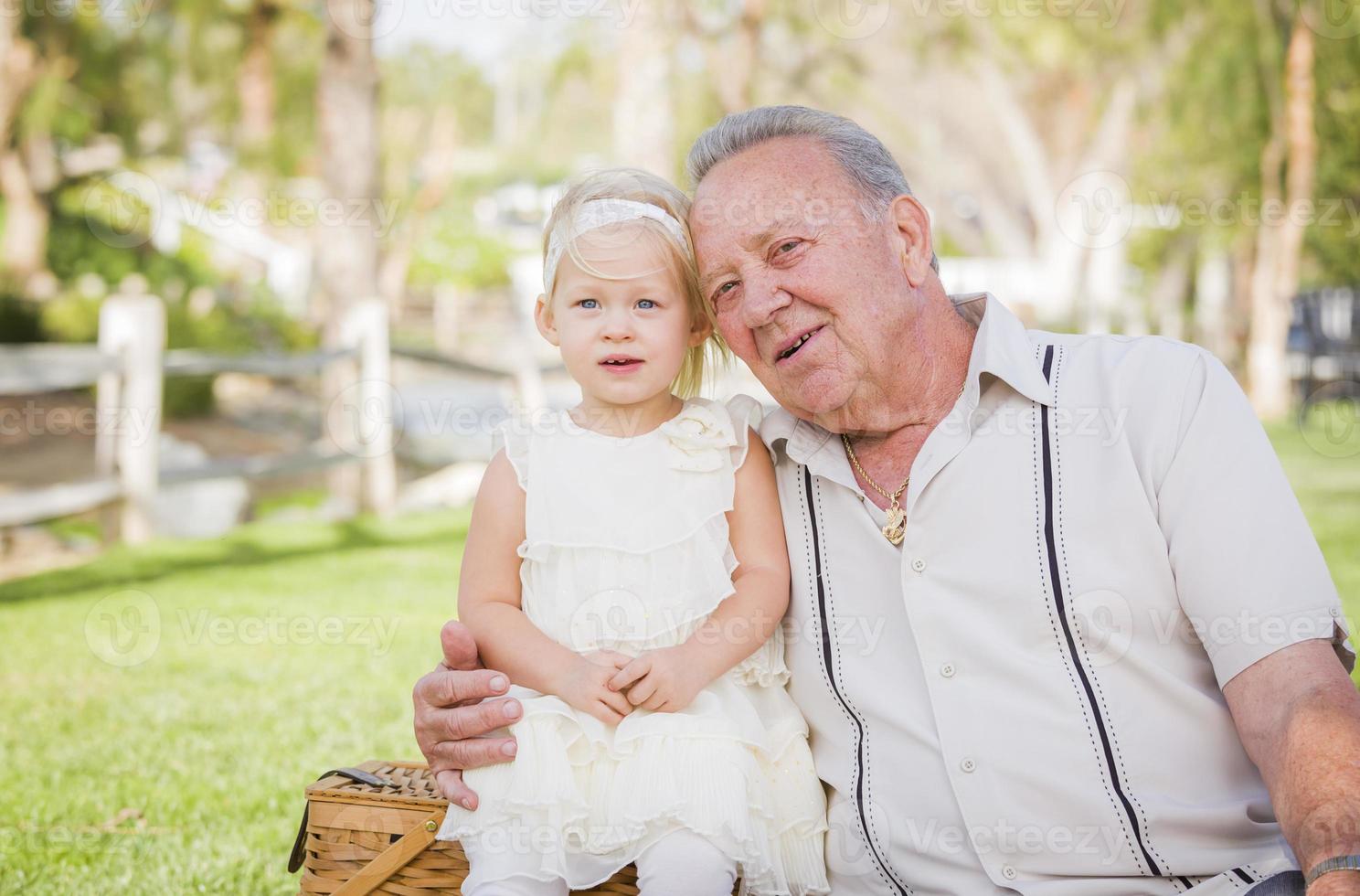 abuelo y nieta abrazándose afuera en el parque foto