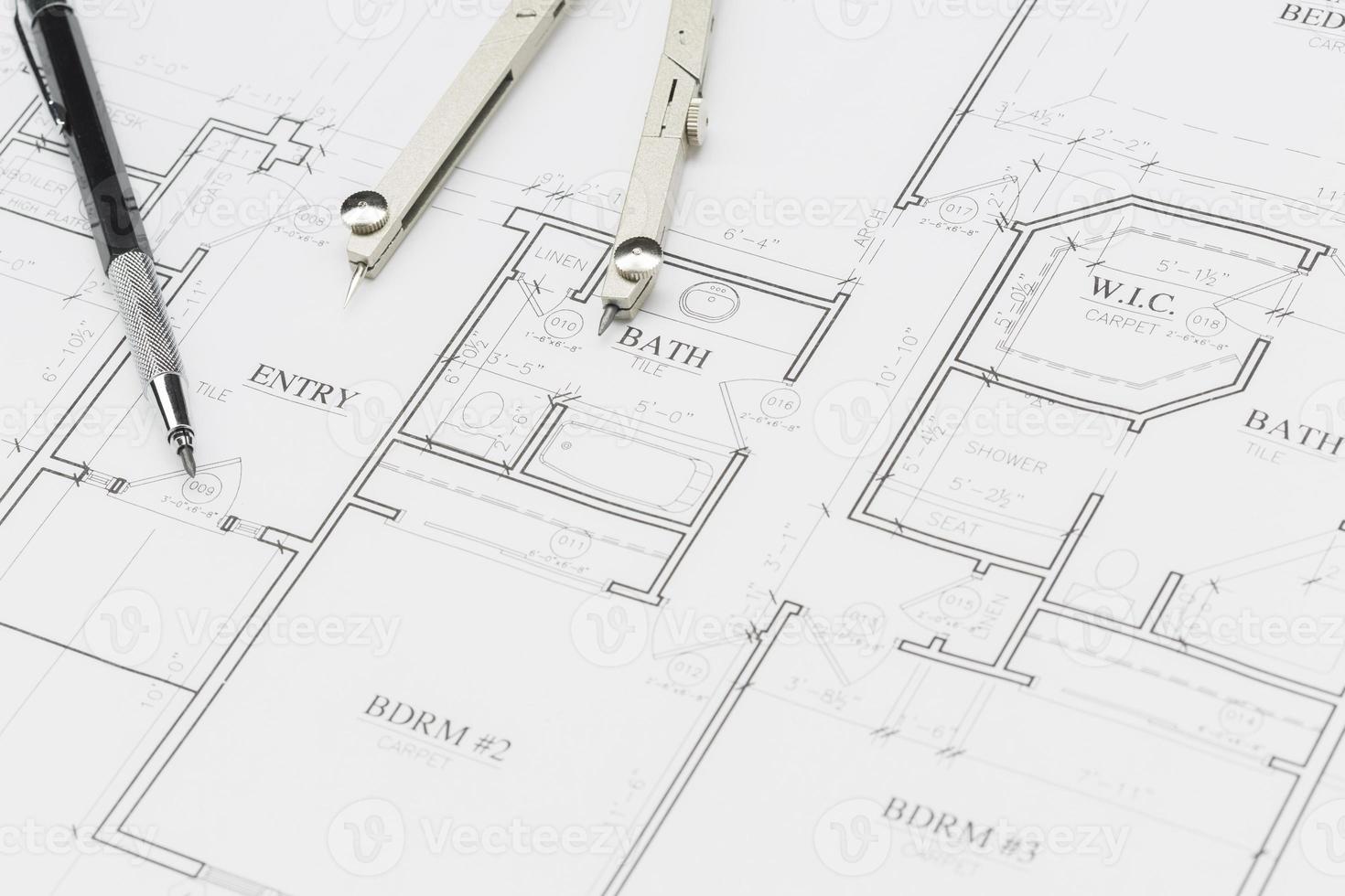 lápiz de ingeniero y brújula descansando sobre los planos de la casa foto