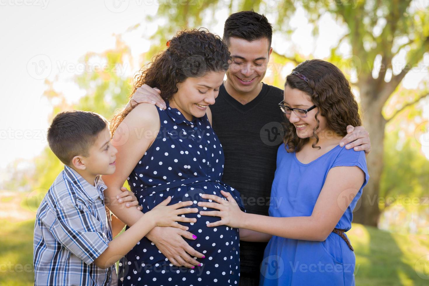 Hispanic Family Hands on Pregnant Mother Tummy Feeling Baby Kick photo