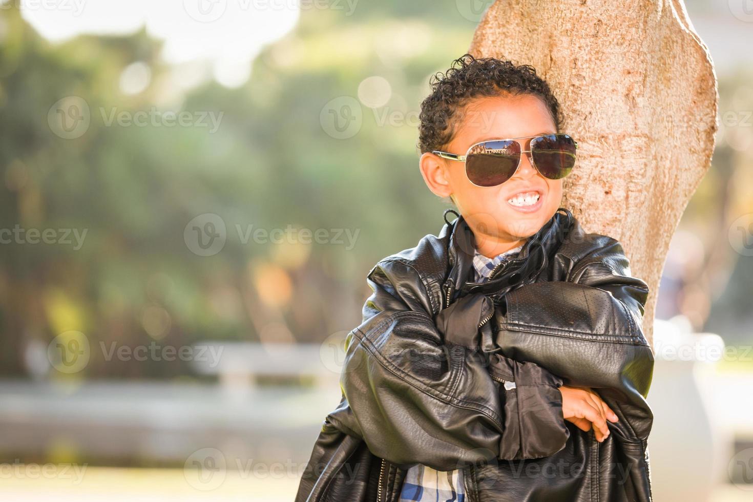 niño afroamericano y mexicano vestido con gafas de sol y chaqueta de cuero foto